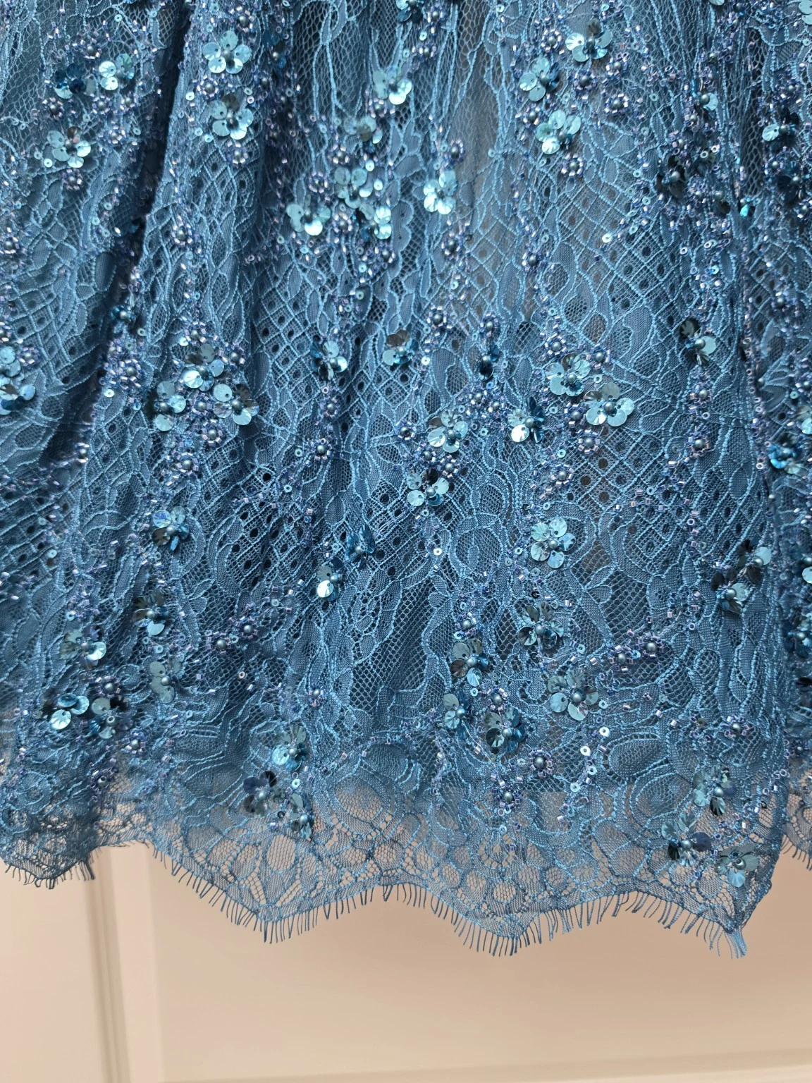 Close-up of intricate blue embroidery on sheer tulle